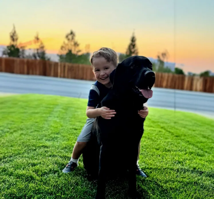 A photo of a boy hugging a dog